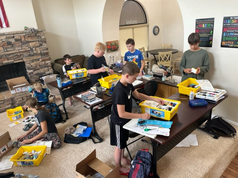 A group of children diligently working on their projects in a room, showcasing their creativity and teamwork.