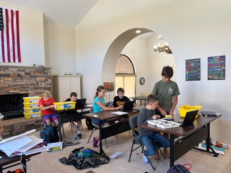 A classroom filled with children diligently working on their laptops, engaged in their studies.