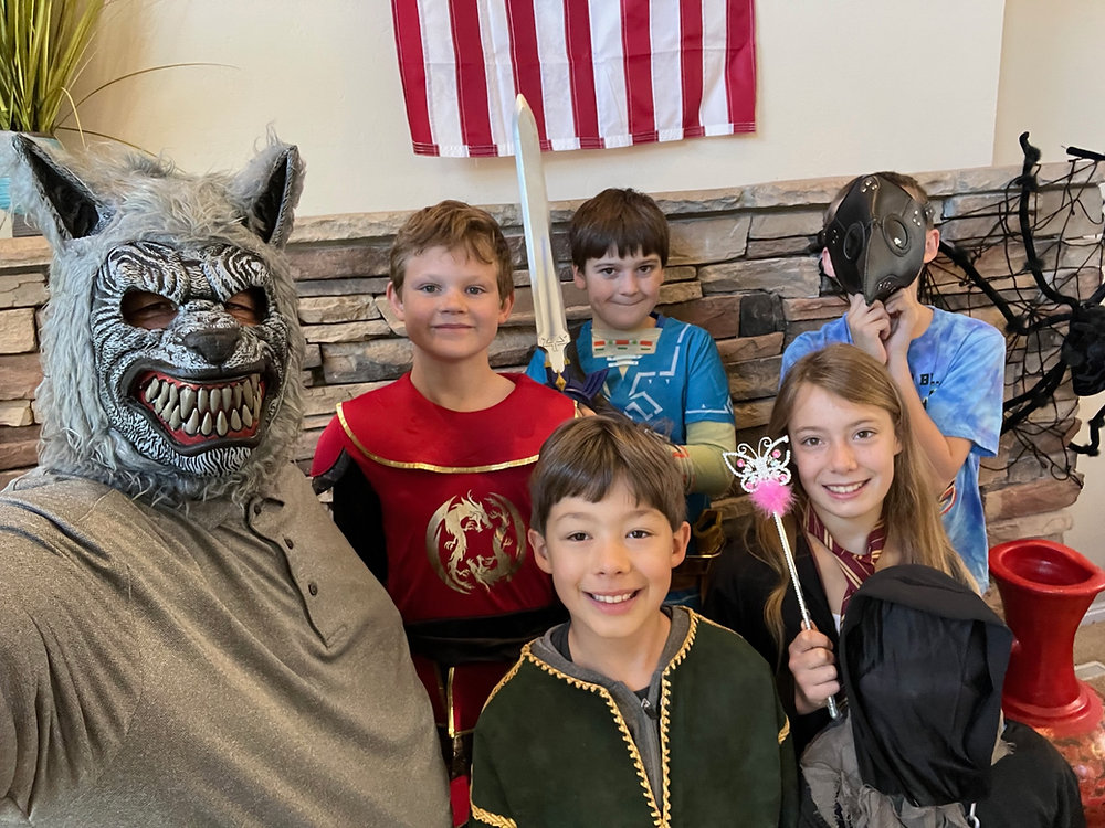 A group of kids wearing wolf masks, posing together for a picture, with smiles and excitement.